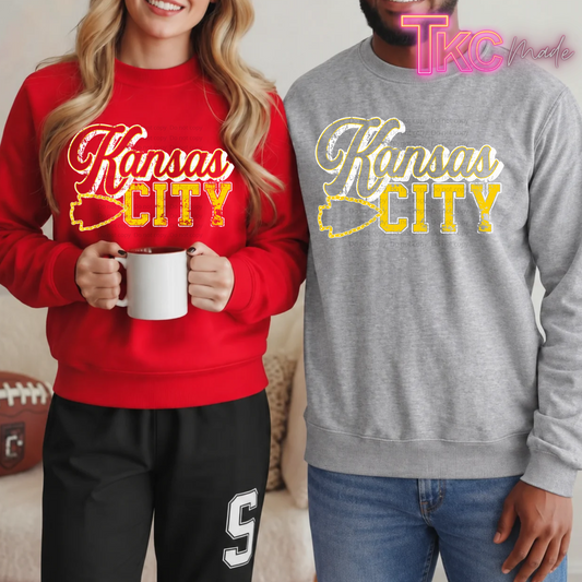 Two models wearing red and gray crewneck sweatshirts with distressed Kansas City lettering  design.