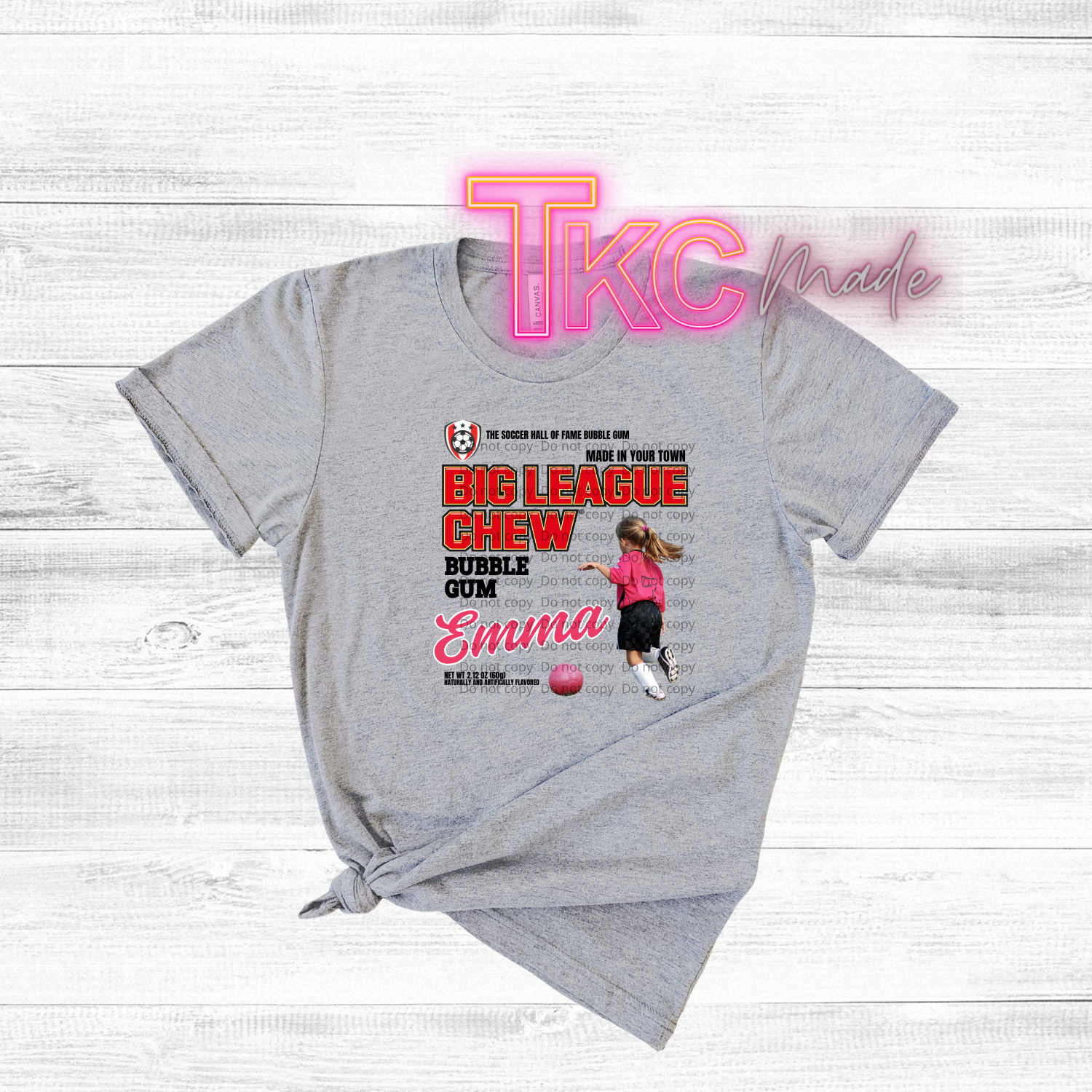 Gray t-shirt with a graphic design featuring a girl with a soccer ball and text on a white background.