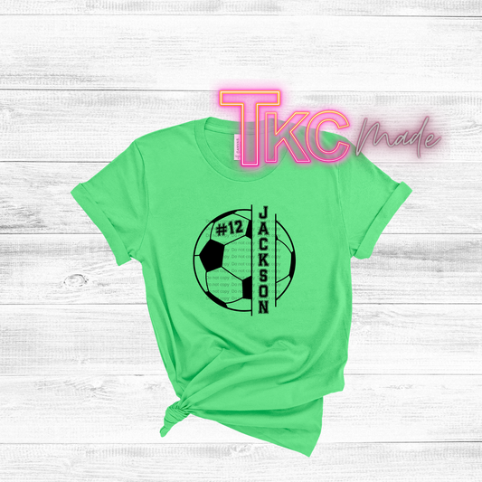 Green t-shirt with soccer ball design and text on a light wooden background