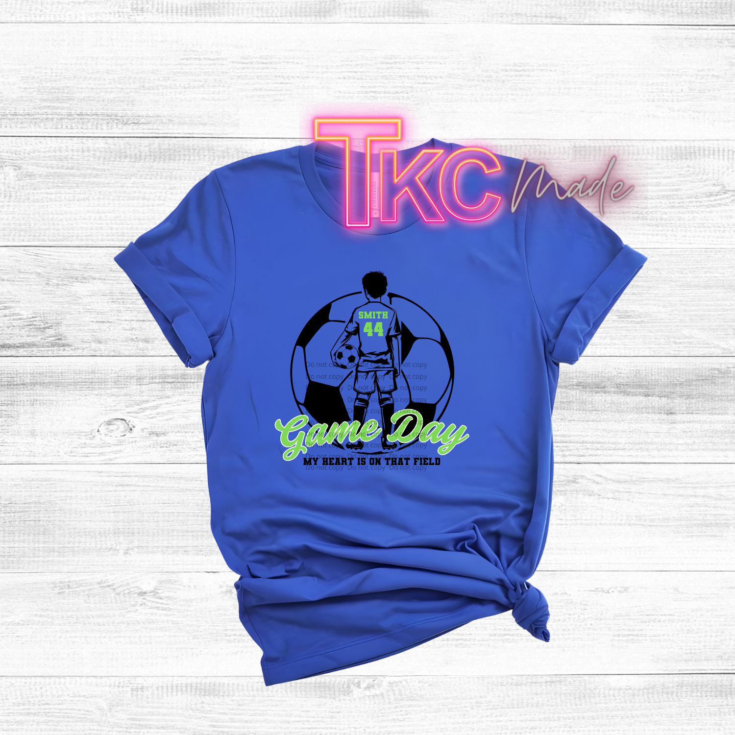 Blue t-shirt with graphic design and text on a light wooden background