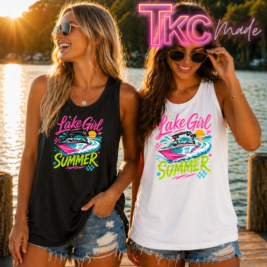 Two women wearing 'Lake Girl Summer' tank tops by a lake.