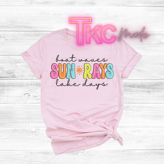 Pink t-shirt with colorful text on a light wooden background