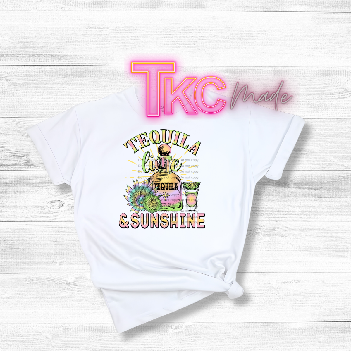 White t-shirt with 'Tequila Lime & Sunshine' graphic and 'TLC Made' branding on a light wooden background.