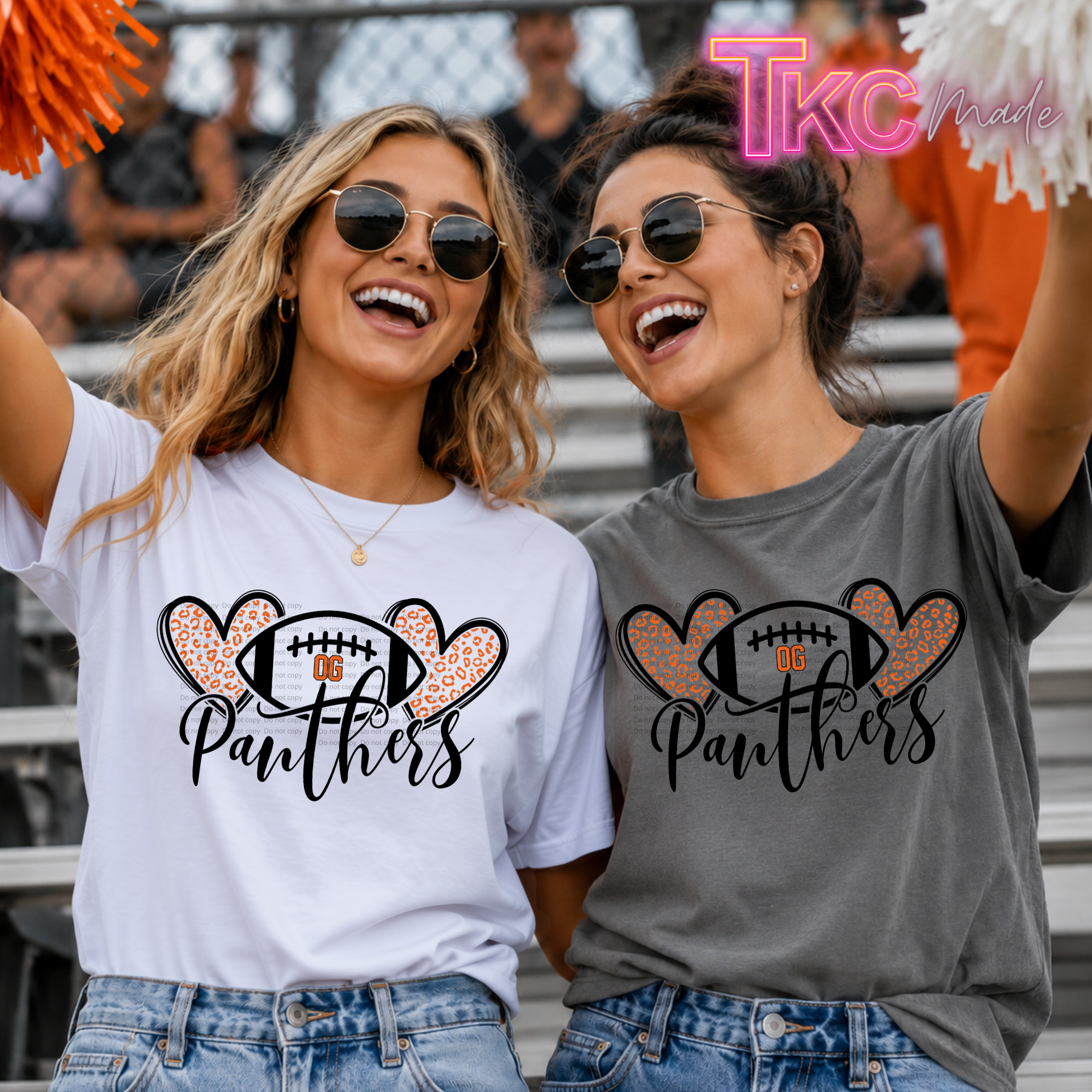 Two women in sunglasses cheering at a sports event, wearing matching graphic t-shirts. The woman on the left wears a white t-shirt and the woman on the right wears a heather gray  Panthers football leopard print t-shirt.