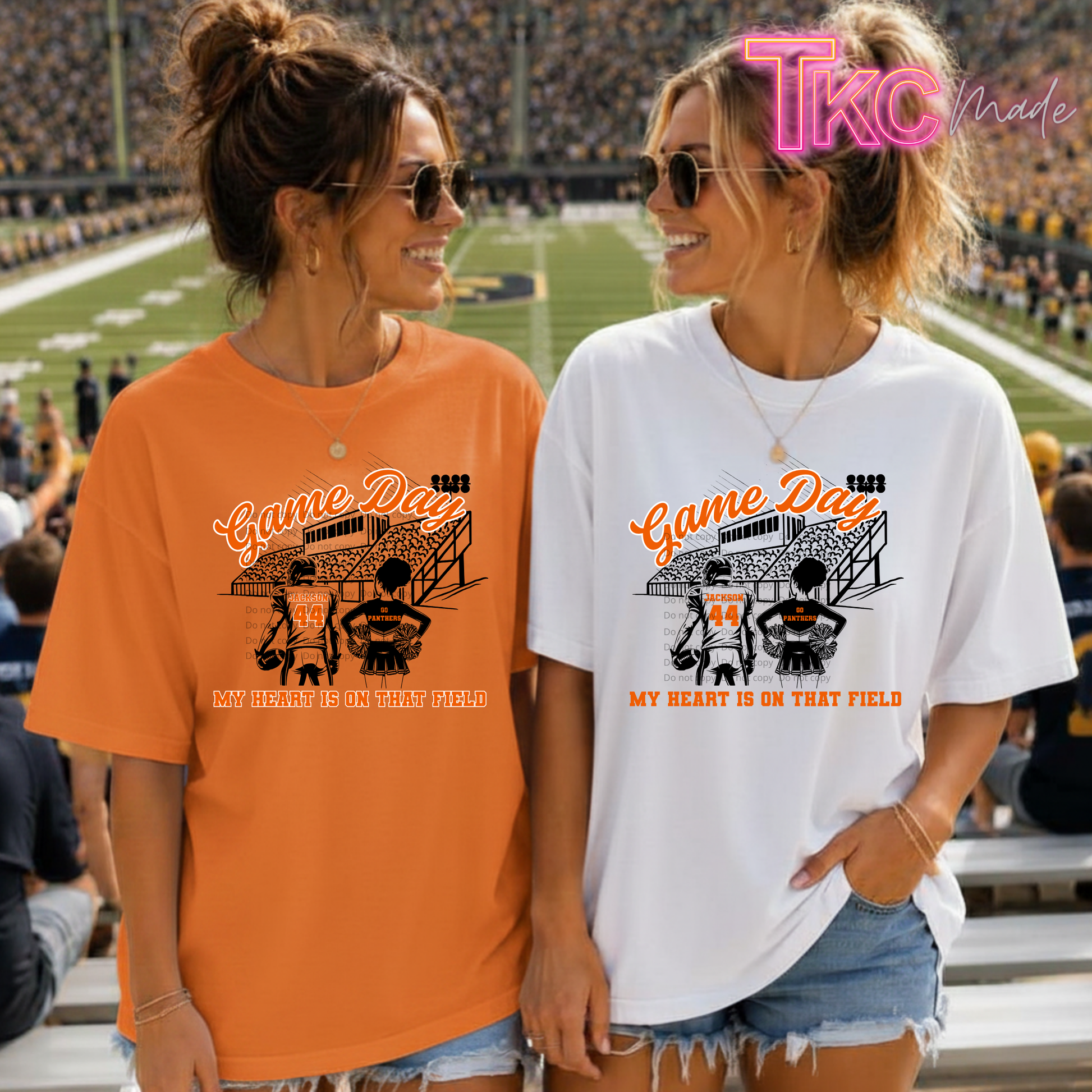 Two women standing in a stadium wearing matching graphic t-shirts game day panthers. The woman on the left wears an orange t-shirt and the woman on the right wears a white t-shirt.