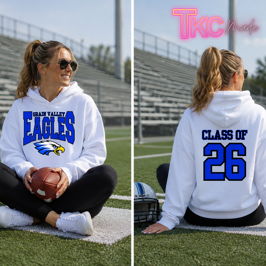 a girl wearing a front and back white hooded sweatshirt that reads Grain Valley Eagles and on the back class of 26.