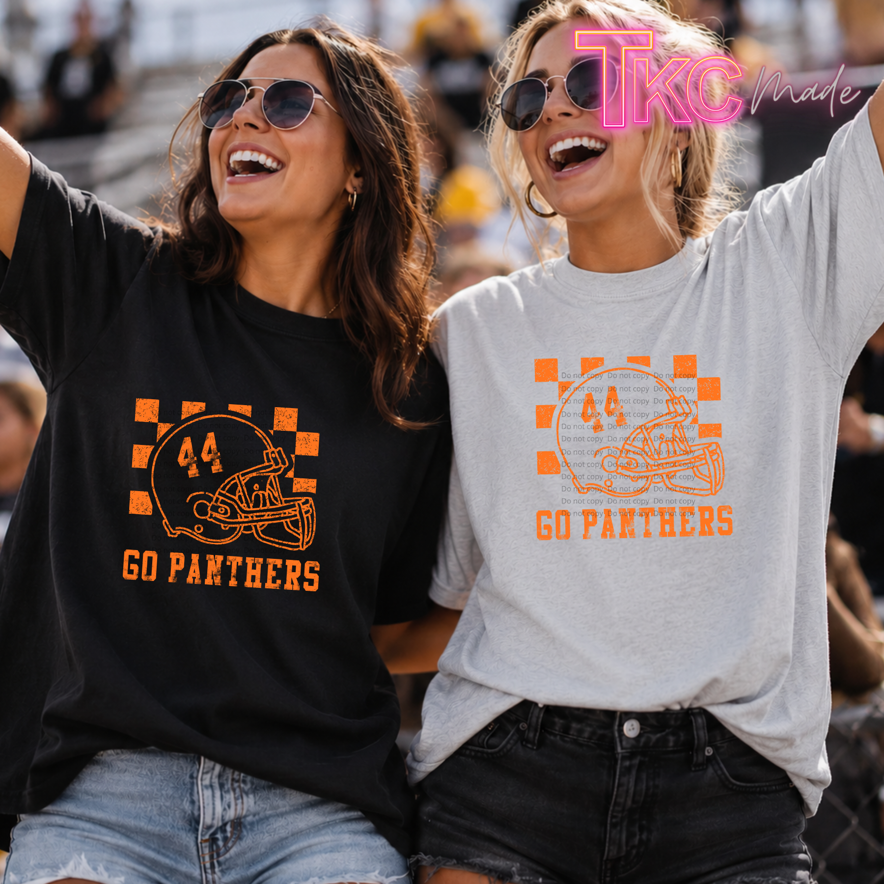 Two women cheering at a sports event wearing team graphic t-shirts. The woman on the left wears a black t-shirt with an orange football helmet graphic and 'GO PANTHERS' text.