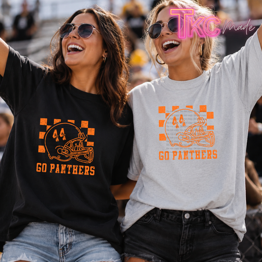 Two women cheering at a sports event wearing team graphic t-shirts. The woman on the left wears a black t-shirt with an orange football helmet graphic and 'GO PANTHERS' text.